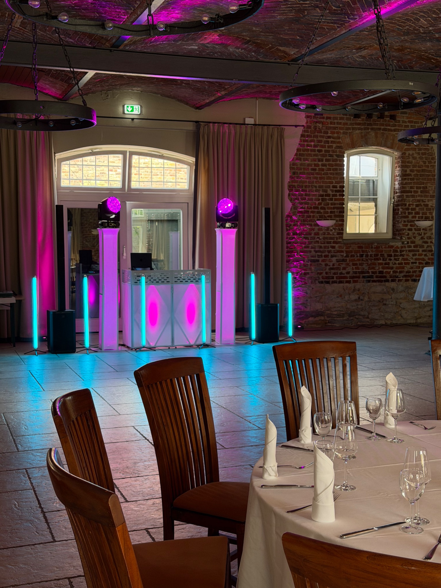 DJ Setup mit pinker Beleuchtung in einer Hochzeitslocation