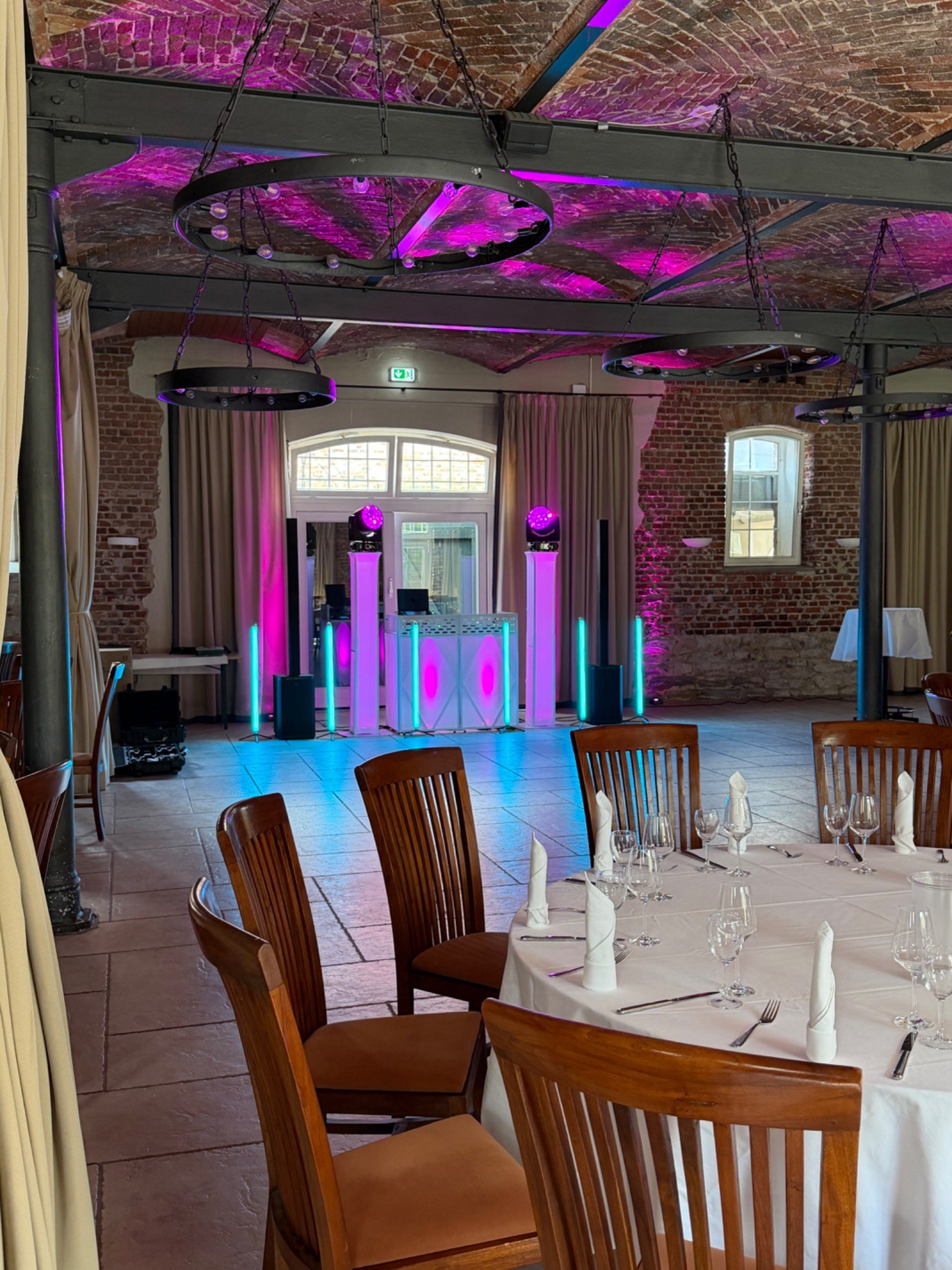 DJ Setup mit Cyan Licht und beleuchtetem Gewölbe